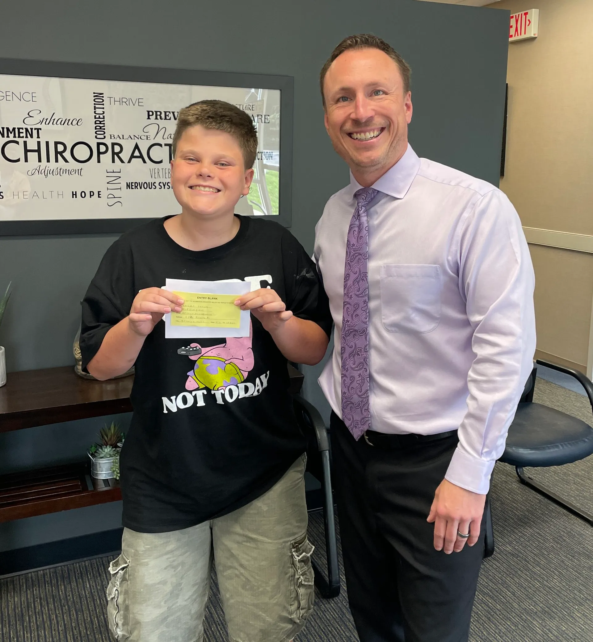 Dr. Charlie Gray with young patient after chiropractic visit