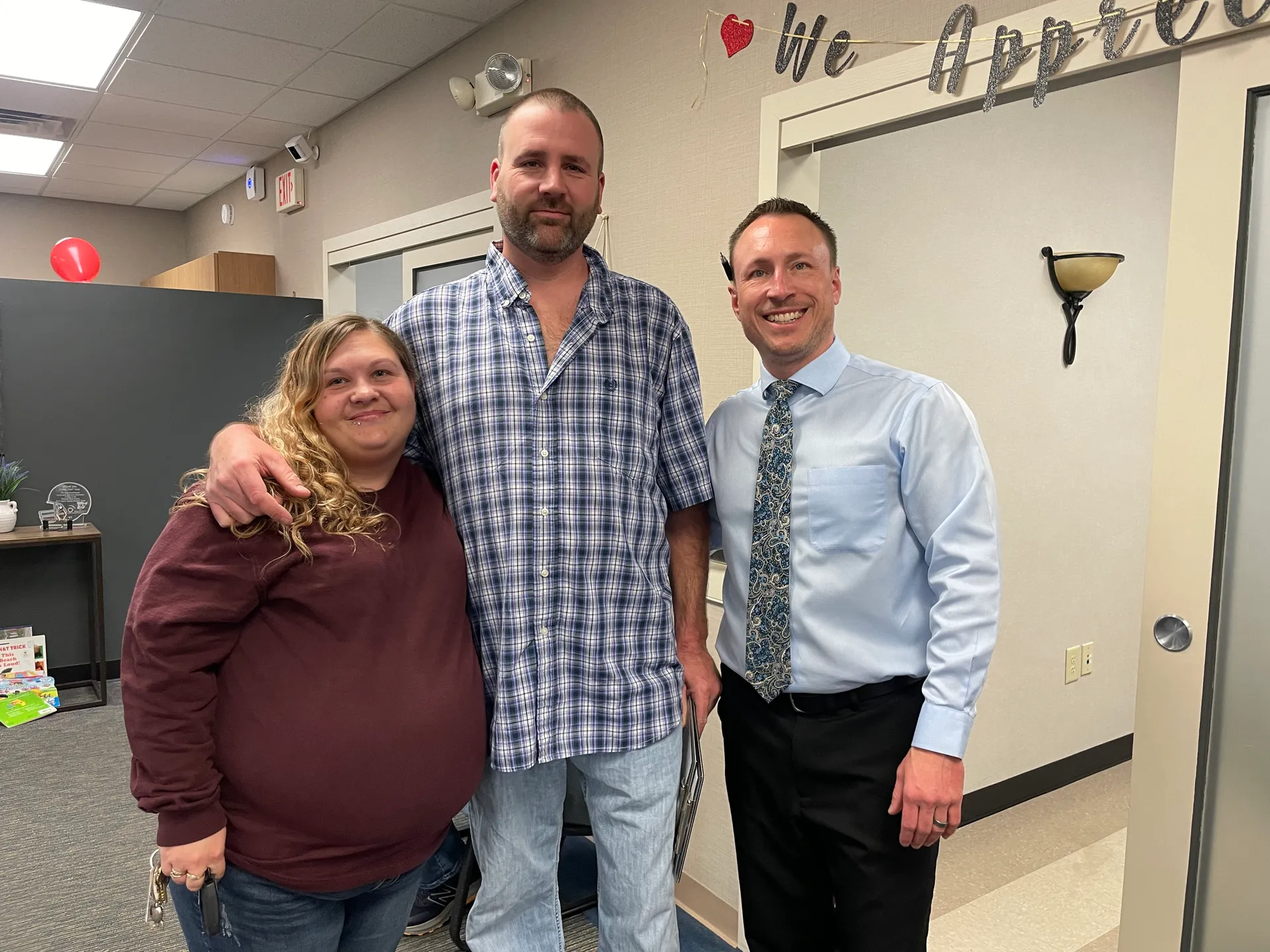 Dr. Charlie Gray with a smiling couple in the clinic hallway