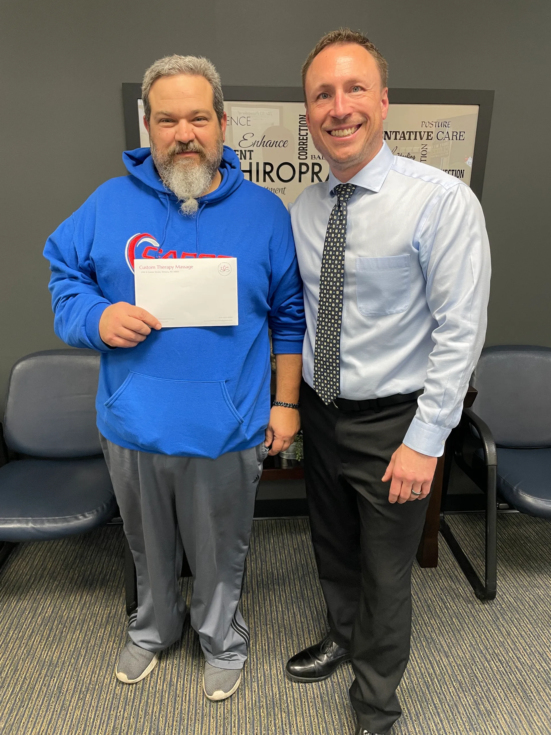 Dr. Charlie Gray with a patient in a blue hoodie holding an envelope