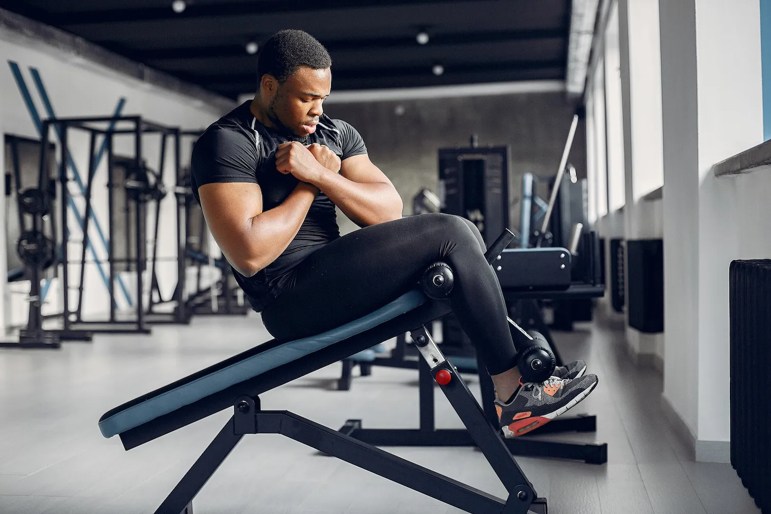 Man doing sit-ups on an incline bench in a gym