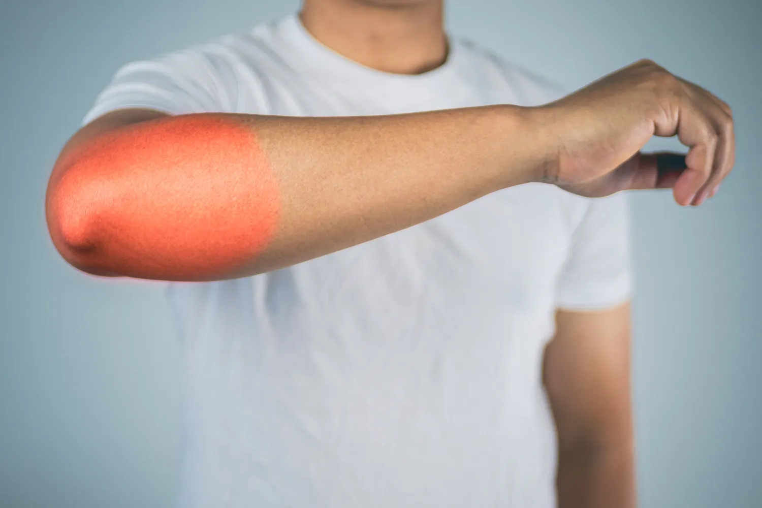 Outstretched arm with the elbow highlighted red to show pain