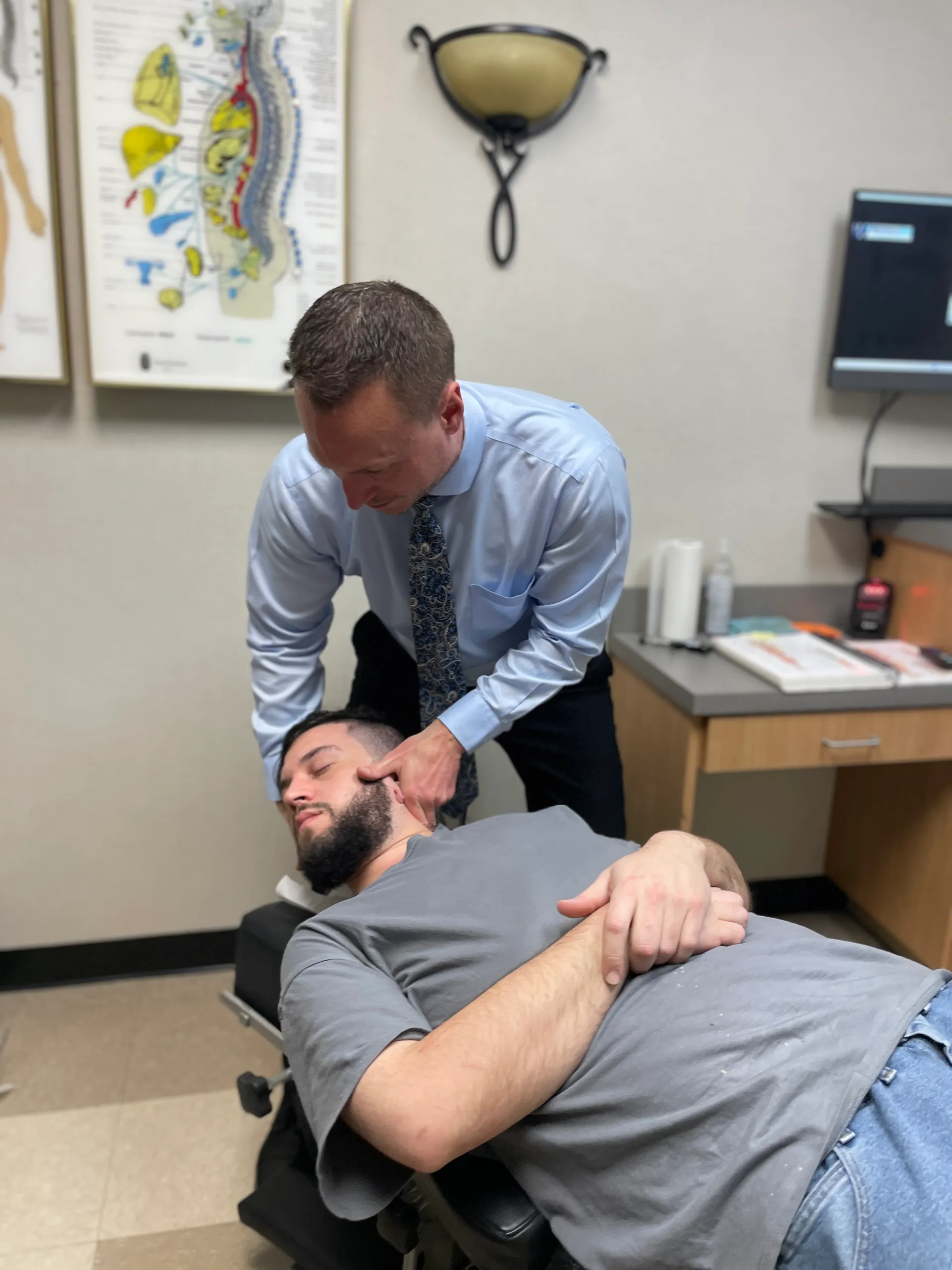 Dr. Charlie Gray giving male patient chiro neck pain treatment