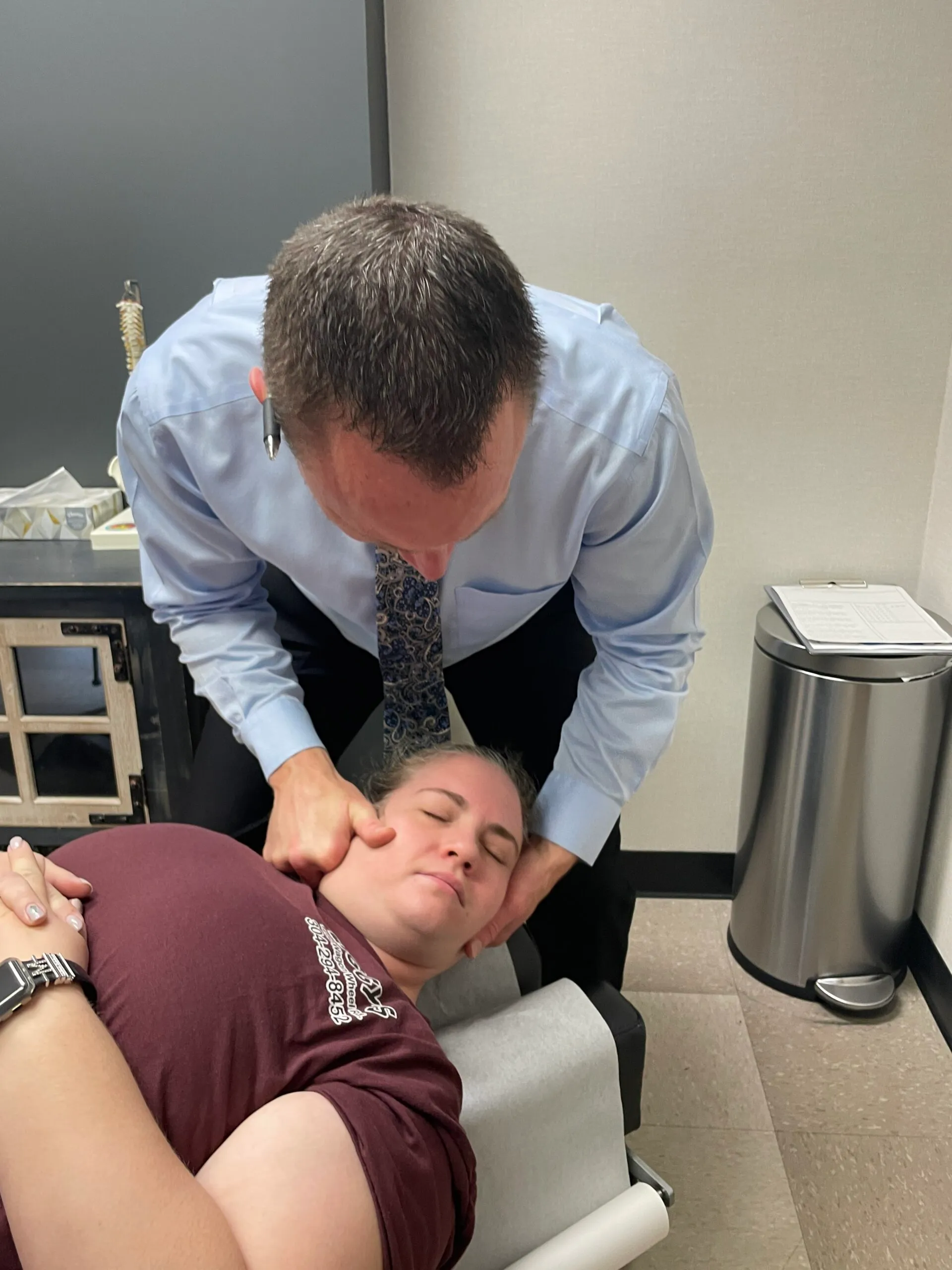 Dr. Charlie Gray giving the lady a neck pain treatment