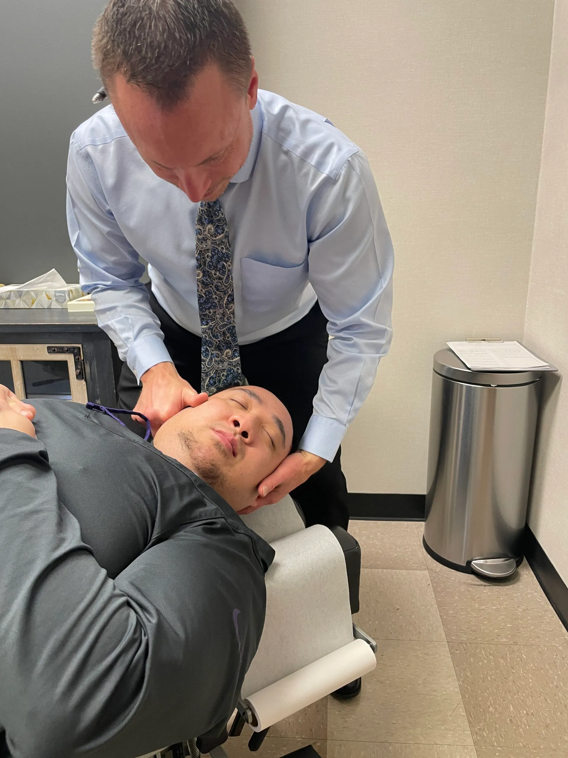 Dr. Charlie Gray giving his patient a neck pain treatment