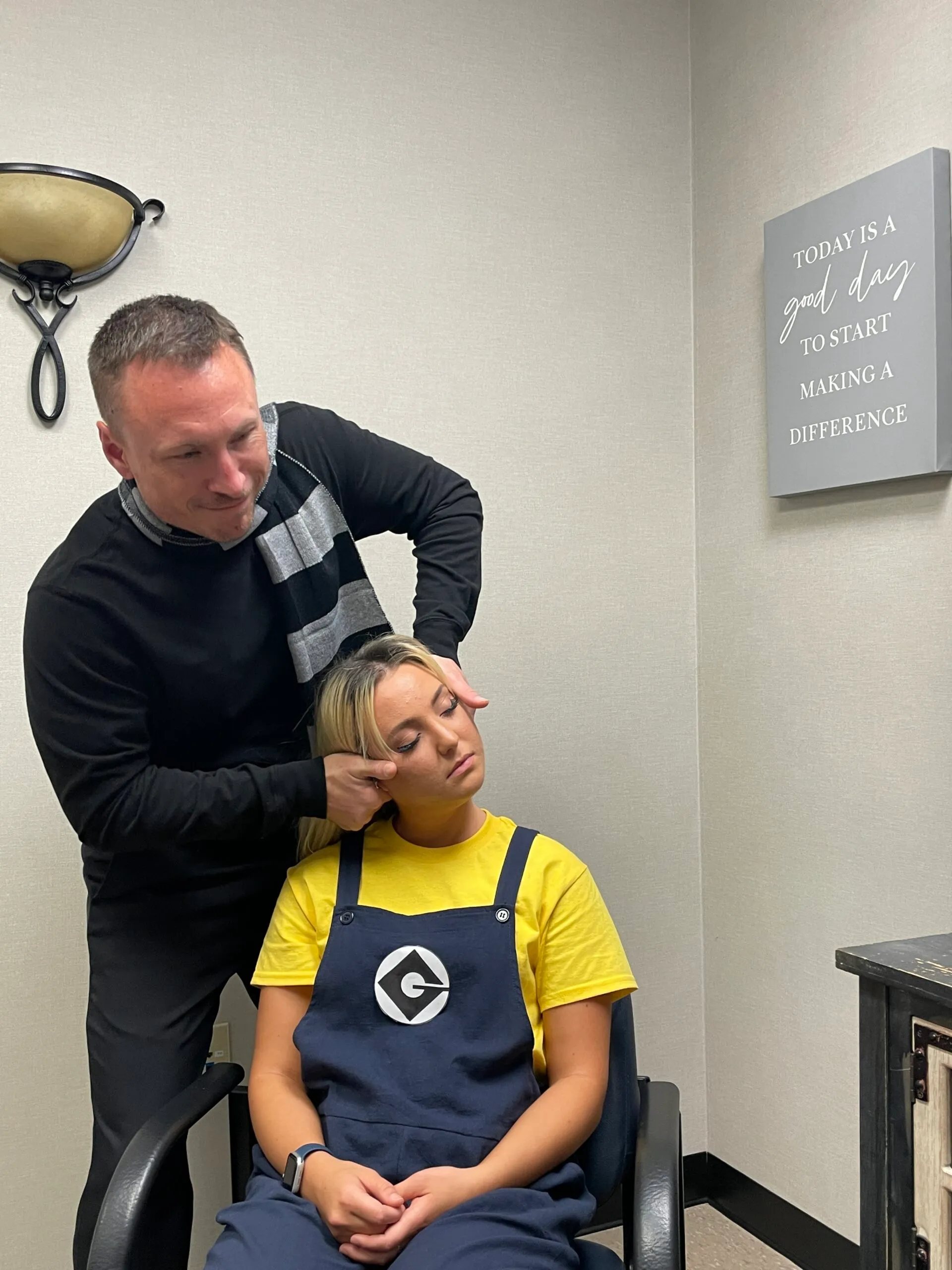 Dr. Charlie Gray giving the woman a neck pain treatment