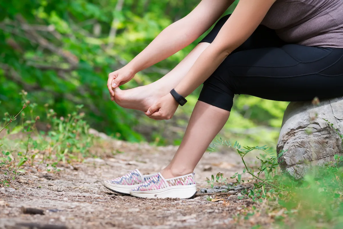 woman having a plantar fasciitis after walking on the mountain