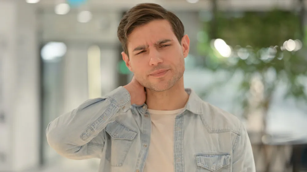 man having a neck pain after poor posture