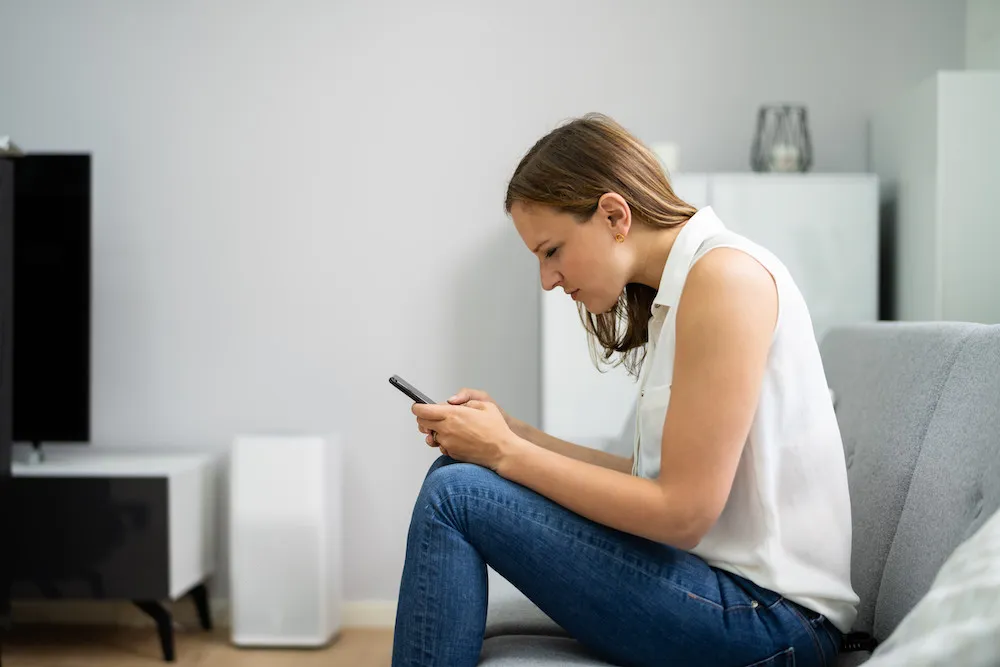 woman having a poor posture while using her phone