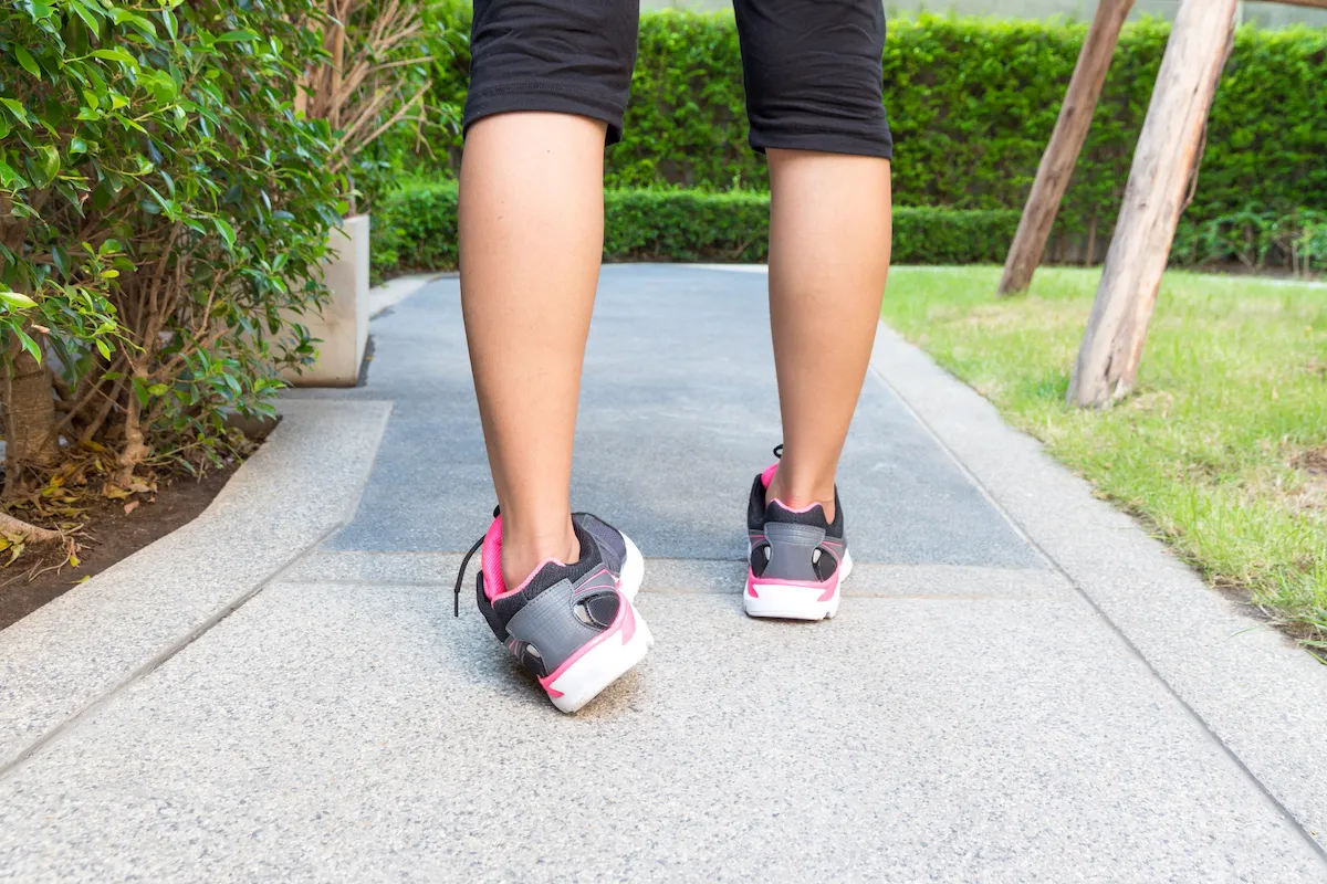 Person on a park path with one ankle rolling inward into a sprain