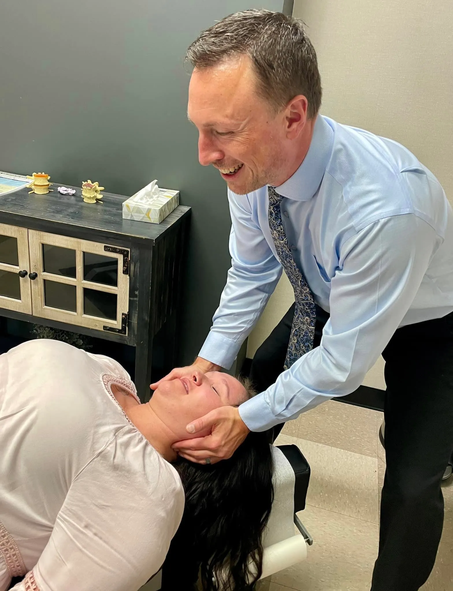 Dr. Charlie Gray giving the lady a whiplash treatment